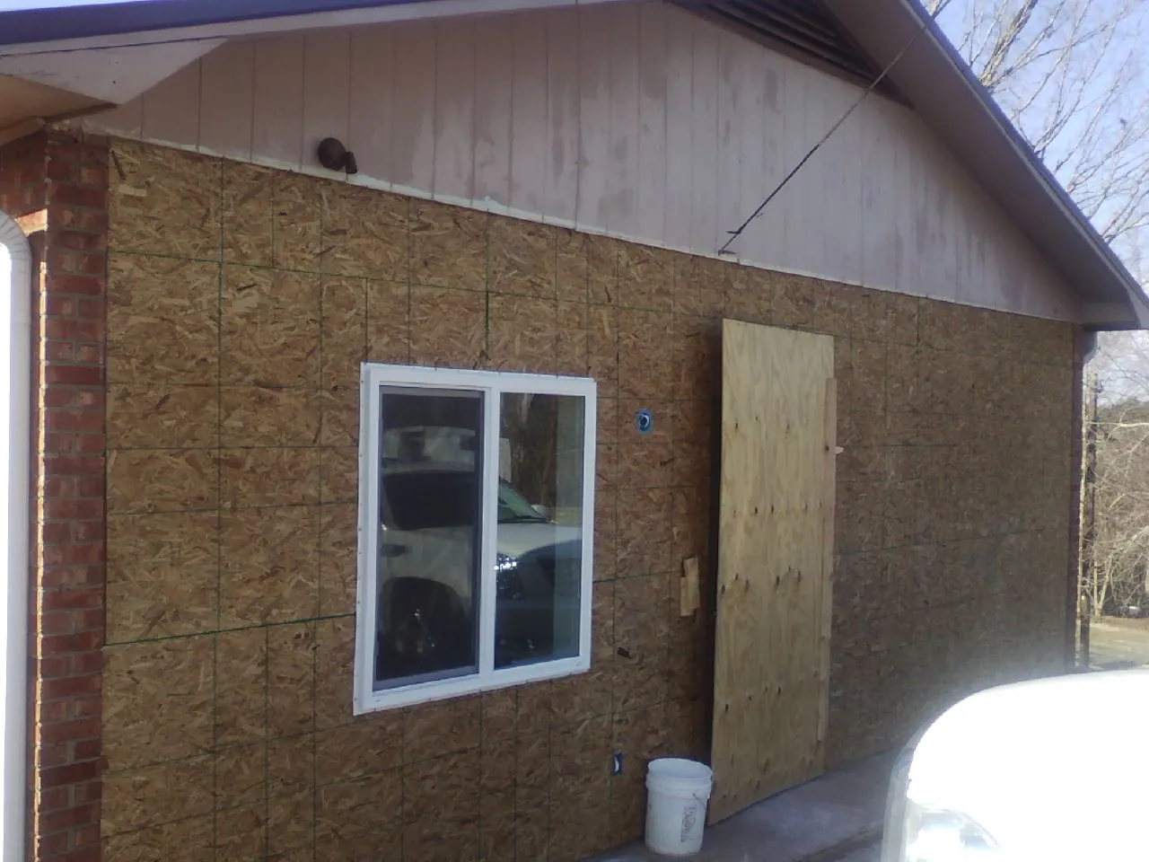 OSB sheathing on a garage addition wall before siding in Limington