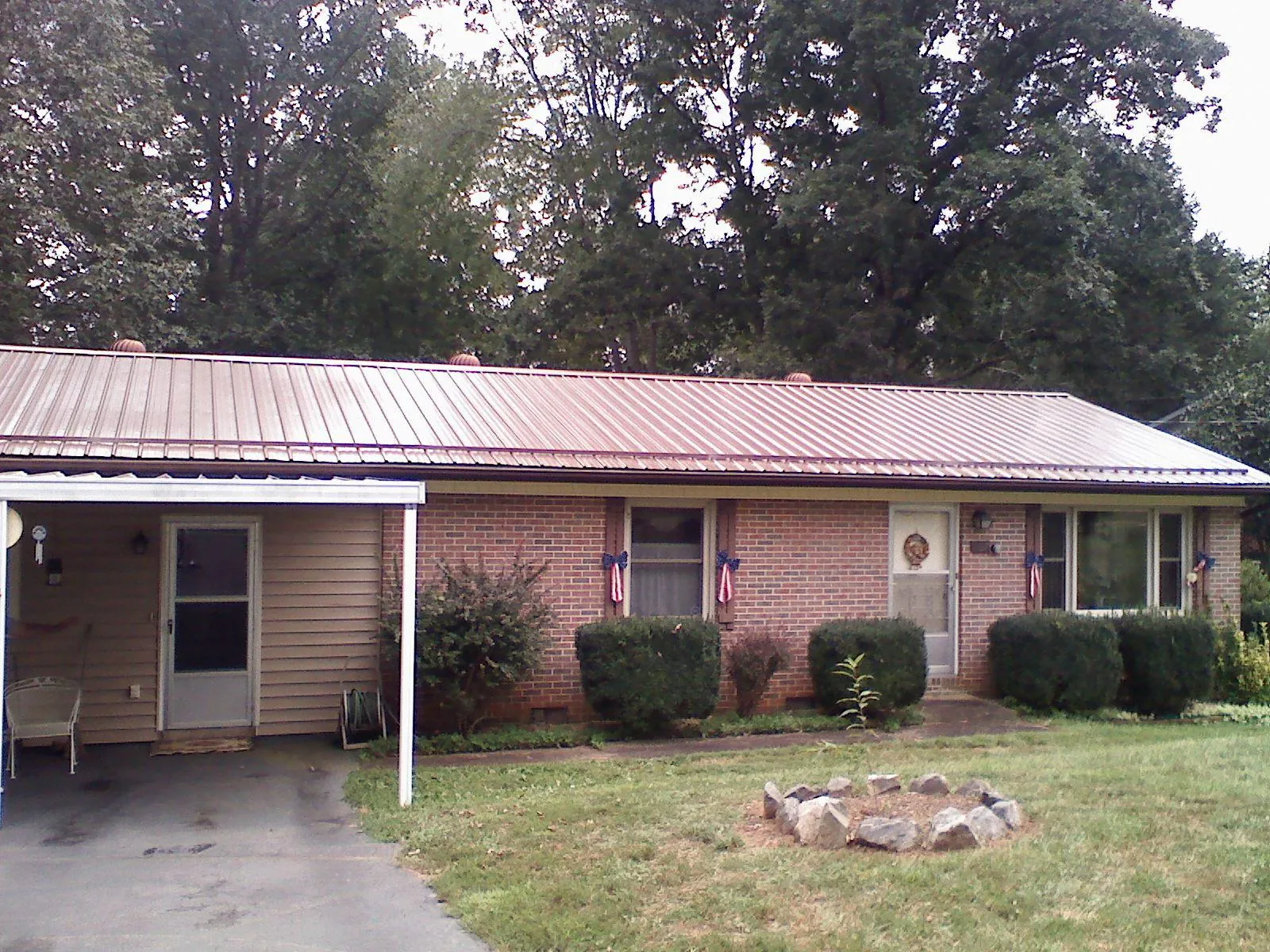 Bronze metal roof and carport on a brick ranch home — Roof Repair work by our crew in Limington
